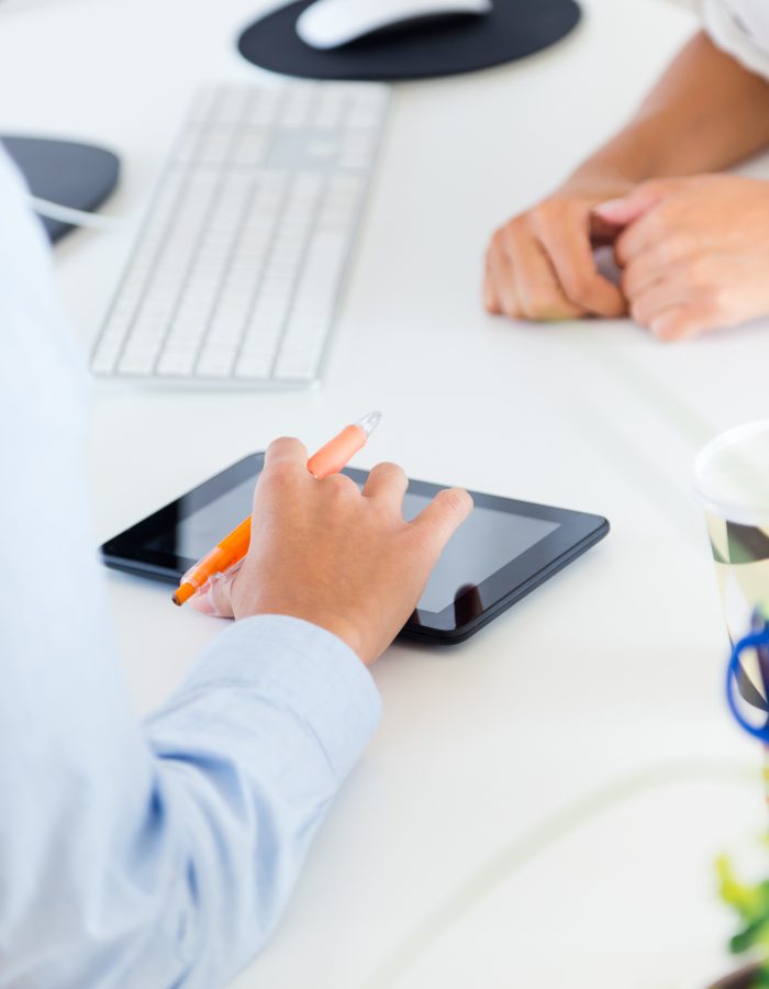 Portrait of two business woman working in office with digital tablet.